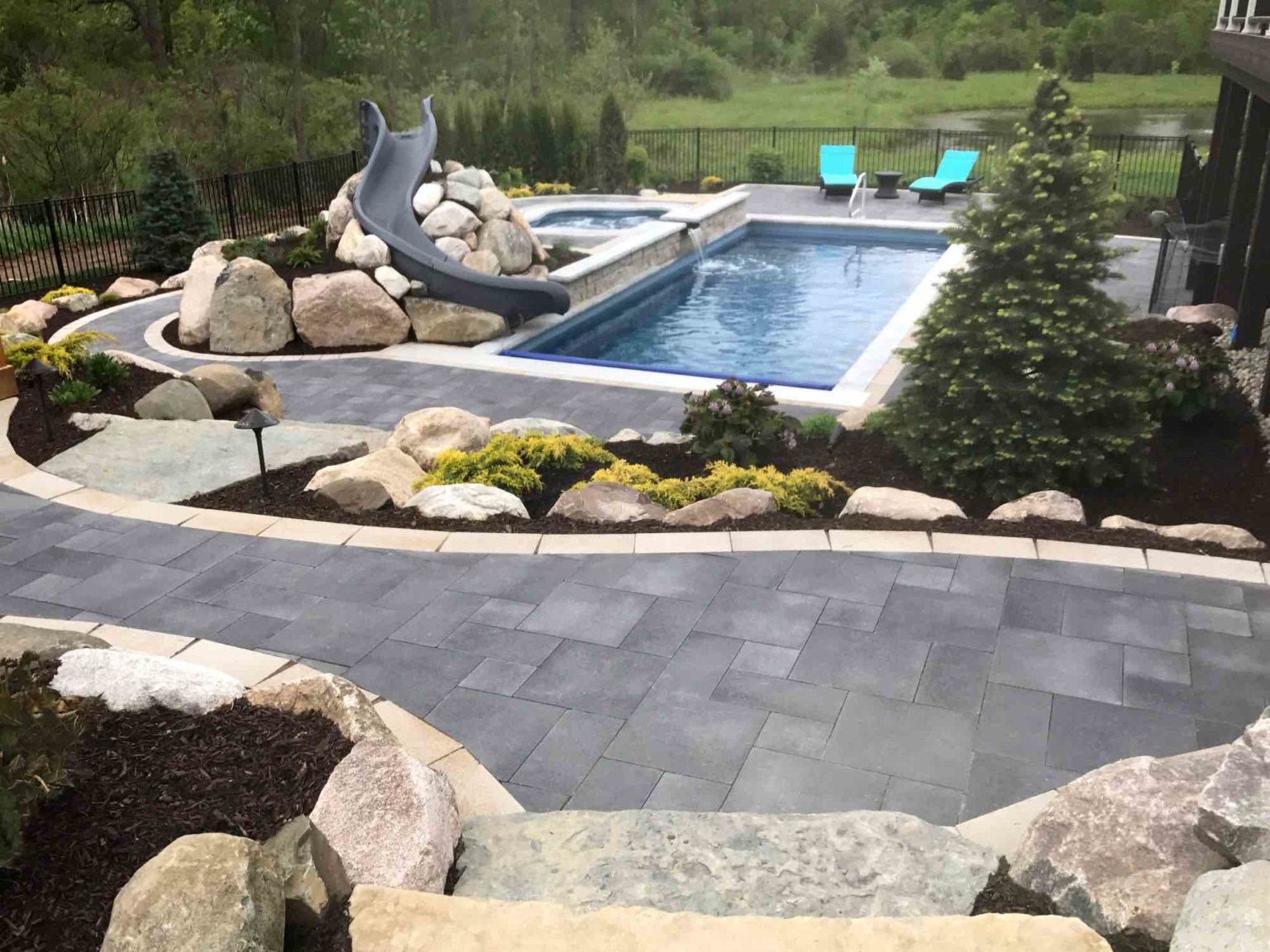 luxurious inground pool contractor in Northville, MI Rectangle fiberglass pool Pool and cascade spa michigan custom pools and spas Sustainable Landscape Design Michigan Michigan Landscaping Ideas Michigan Hardscape Design Award-Winning Landscape Design Michigan