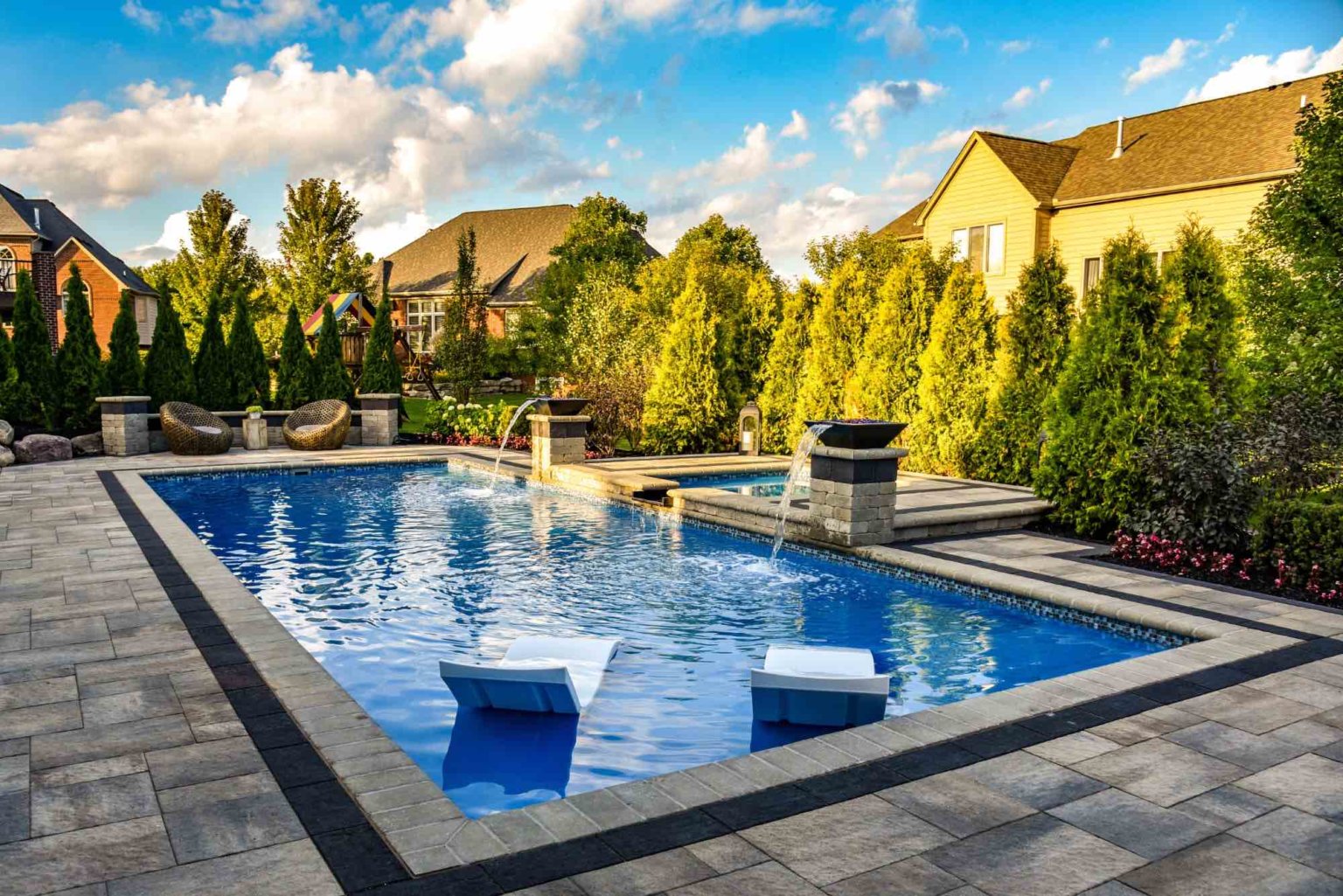 Arborvitae privacy trees  fiberglass pool designers in Shelby Twp, Mi landscape design project in Shelby Township cascade fiberglass swimming pool design with a raised spillover spa  pool and spa design Metro Detroit Metro Detroit pool and spa experts Custom pool design Metro Detroit Spa installation in Metro Detroit Metro Detroit outdoor spa design Residential pool design Metro Detroit Metro Detroit luxury pool and spa
