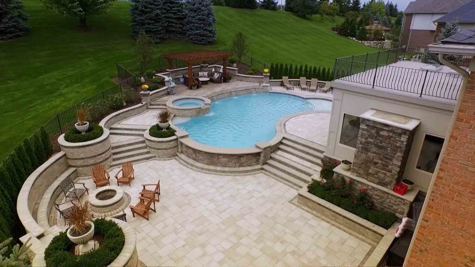 view of backyard patio, fire pit, seating, pool and spillover spa