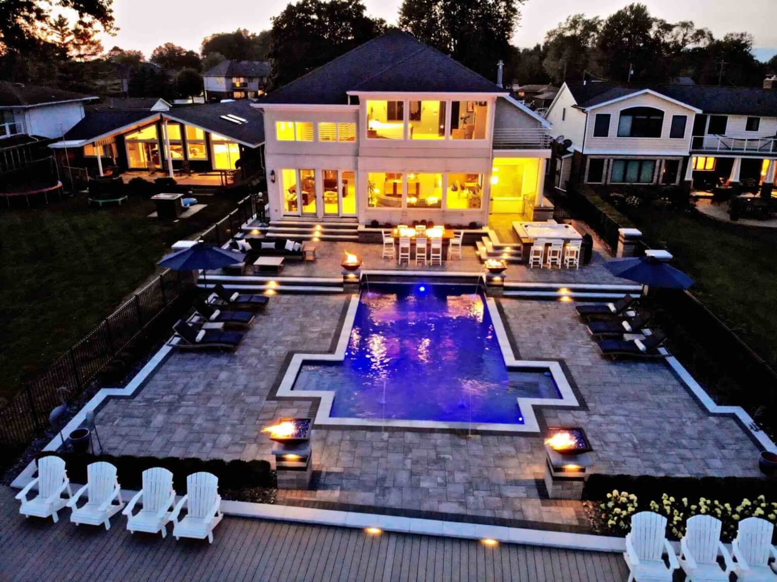 evening view of lakeside pool and patio