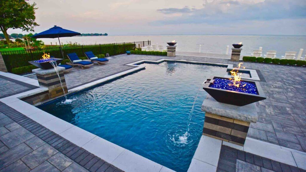 in-ground pool with fire features, brick pavers, fountain