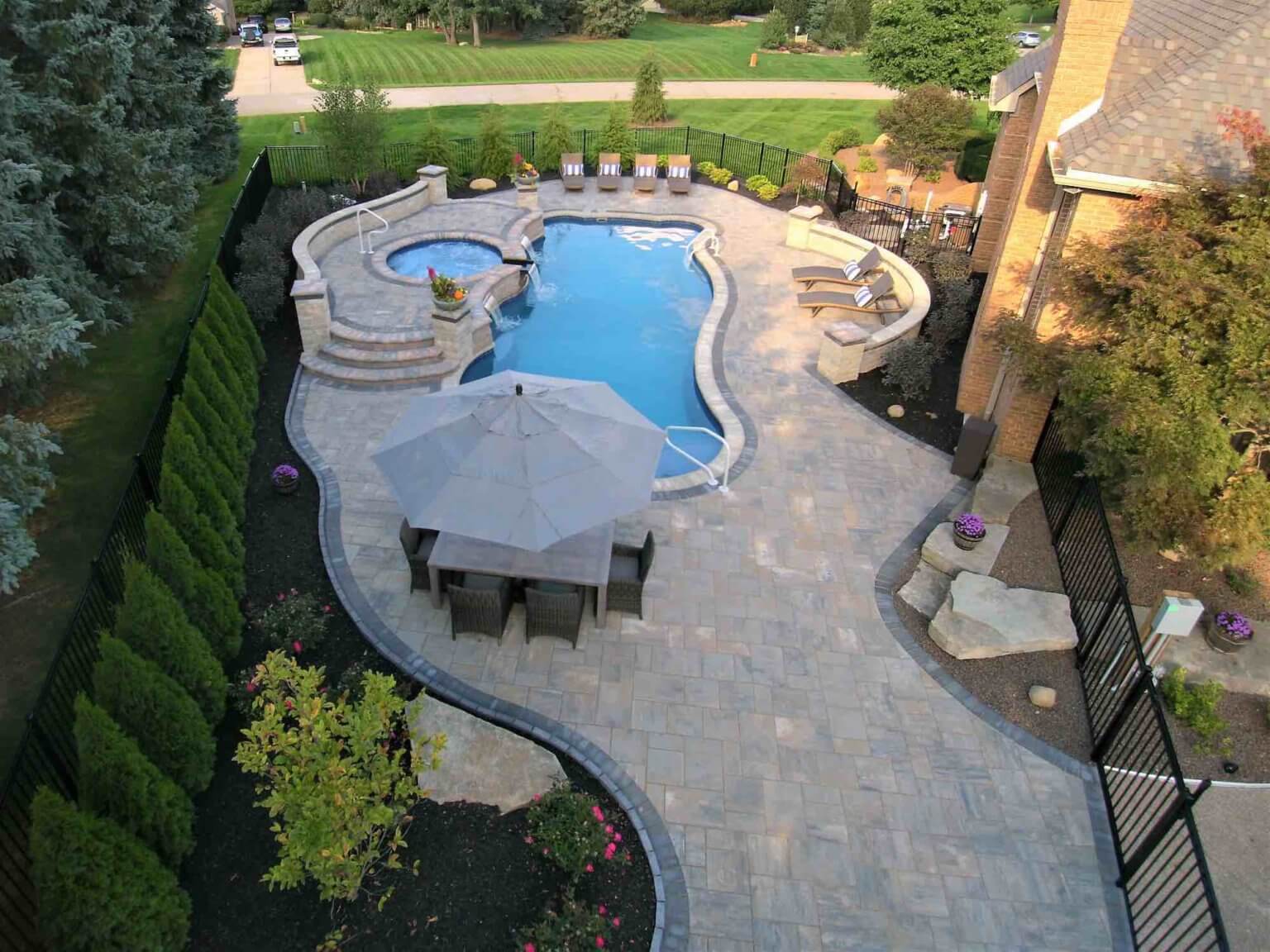 aerial view of pool with a spillover hot tub